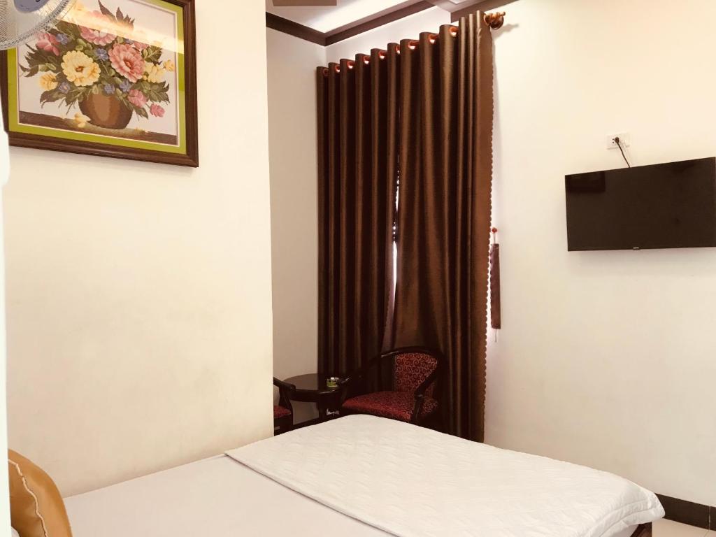 a room with a bed and a window with curtains at Khách sạn Thu Thảo in Phan Rang
