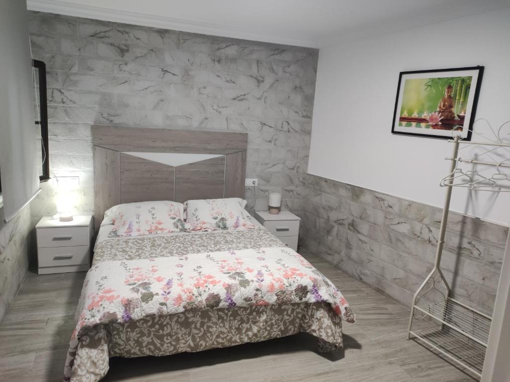 a bedroom with a bed and a stone wall at Apartamento Daniela 1 in Ronda