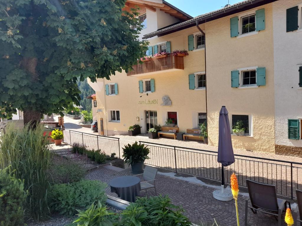 - une vue sur l'extérieur d'un bâtiment avec un parasol dans l'établissement Zum Löwen-Post, à Trodena