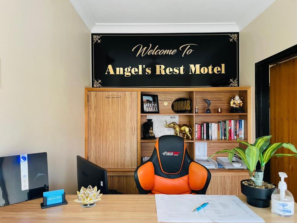 ein Büro mit einem Schreibtisch mit einem Stuhl und einem Schild in der Unterkunft Angel's Rest Motel in Moree