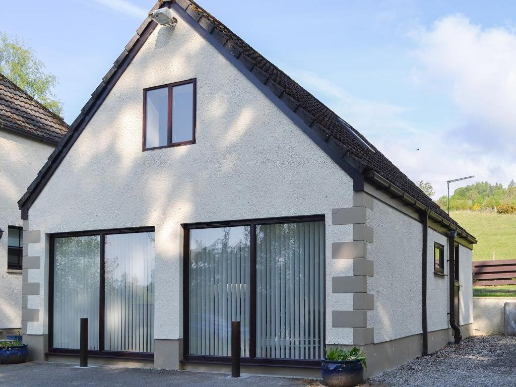 a white house with large windows at Blueberry Hill in Beauly