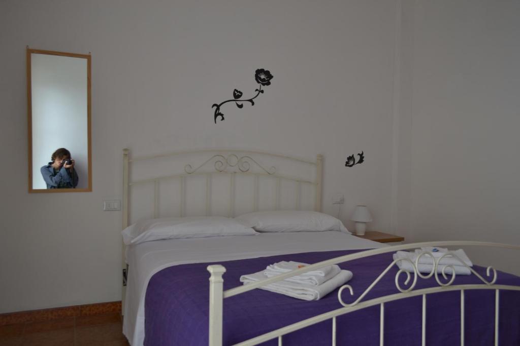 ピサにあるCisanello Appartamenti Teresaの寝室のベッド写真を撮る女性