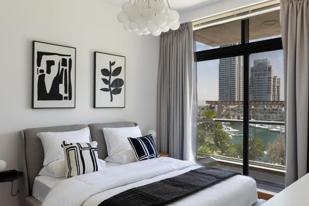 een slaapkamer met een bed en een groot raam bij Dubai Marina, Two bedrooms apartment with full Marina View in Dubai