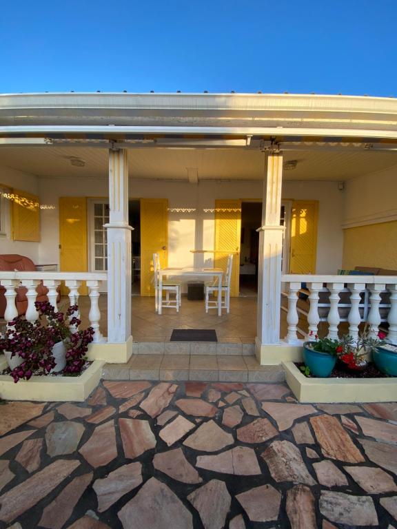 a porch of a house with pillars and plants at Les Capucines in Saint-Pierre