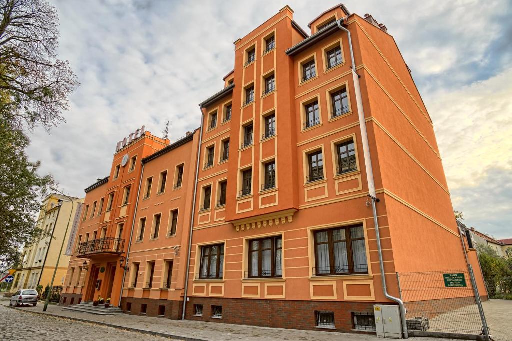 a large orange building on the side of a street at Hotel Kamieniczka in Legnica