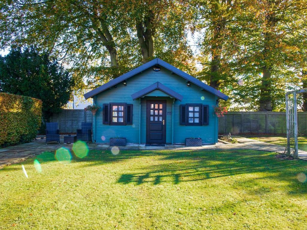 a blue tiny house in a yard at Cabin Hideaways, Glengoyne - Uk38363 in Mattishall