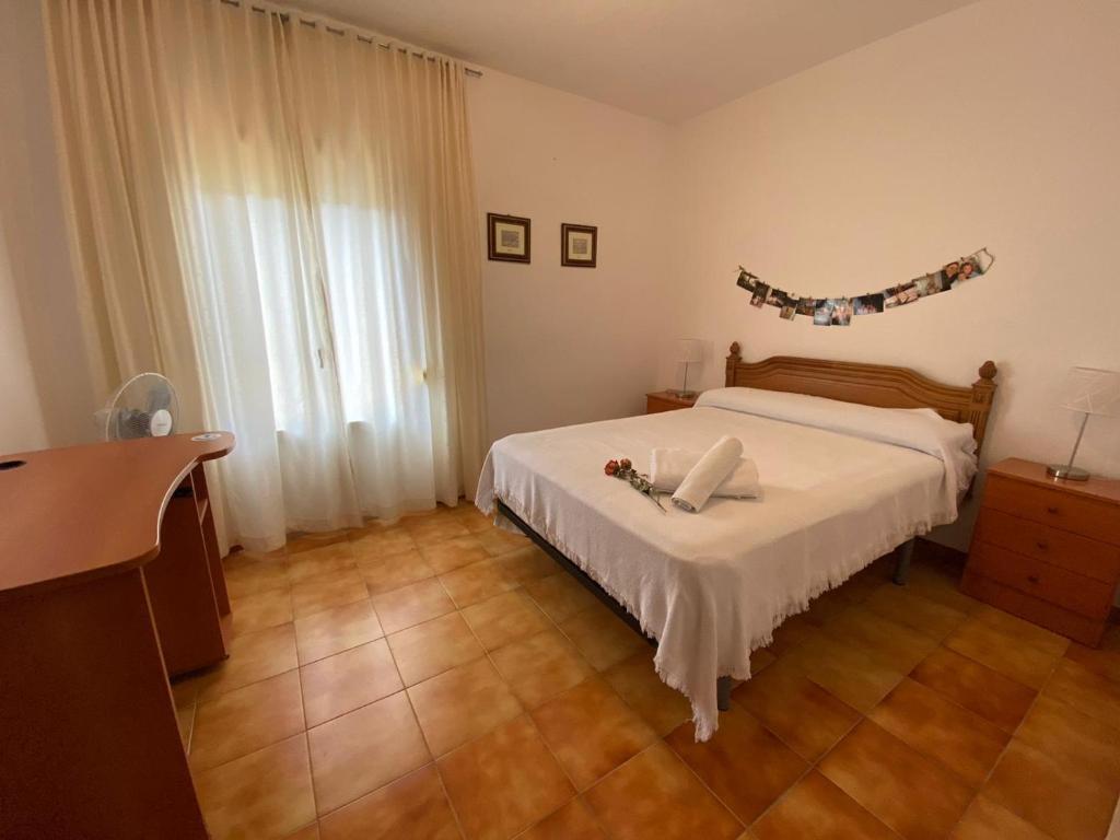 1 dormitorio con cama blanca y suelo de madera en Barrero 47, en Igualeja