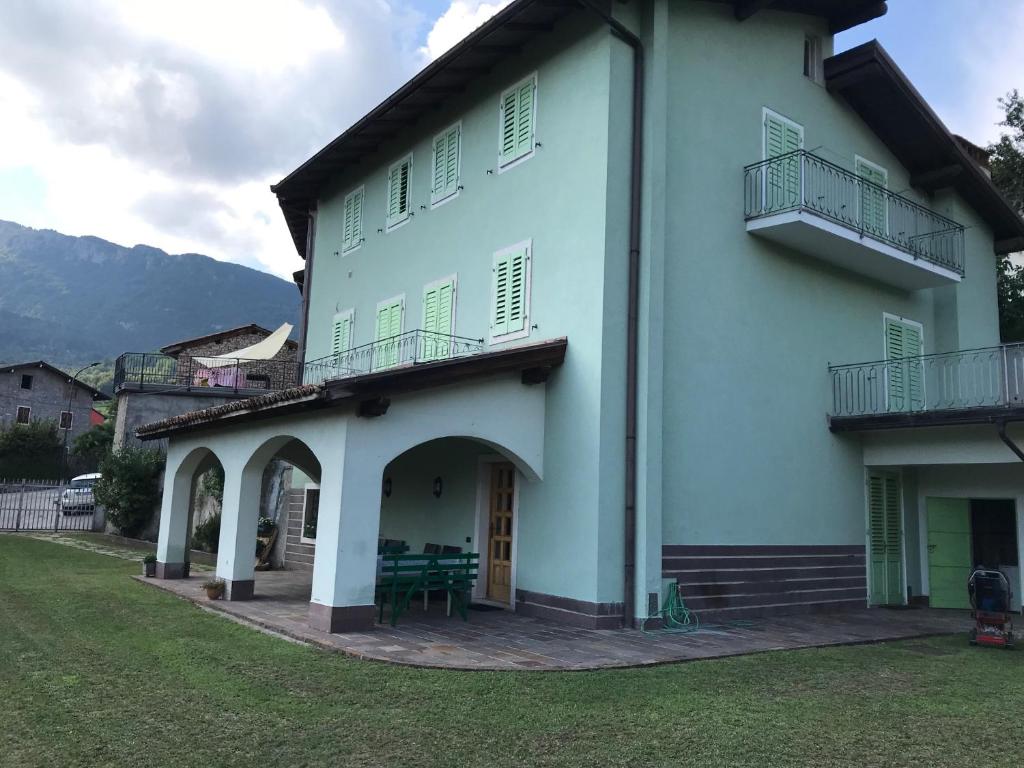 a large white building with a porch and balcony at CA' EDDA APPARTAMENTO ANNA in Brentonico