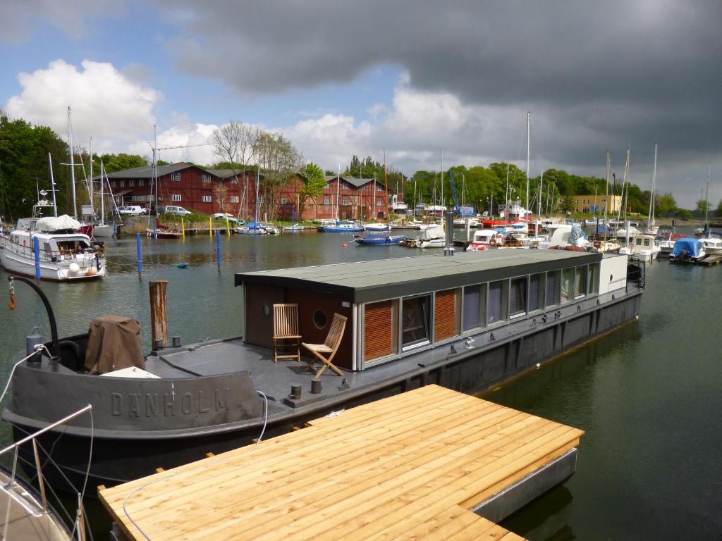 ein Boot, das an einem Yachthafen mit einer Hütte angedockt ist in der Unterkunft Hausboot Dänholm in Stralsund
