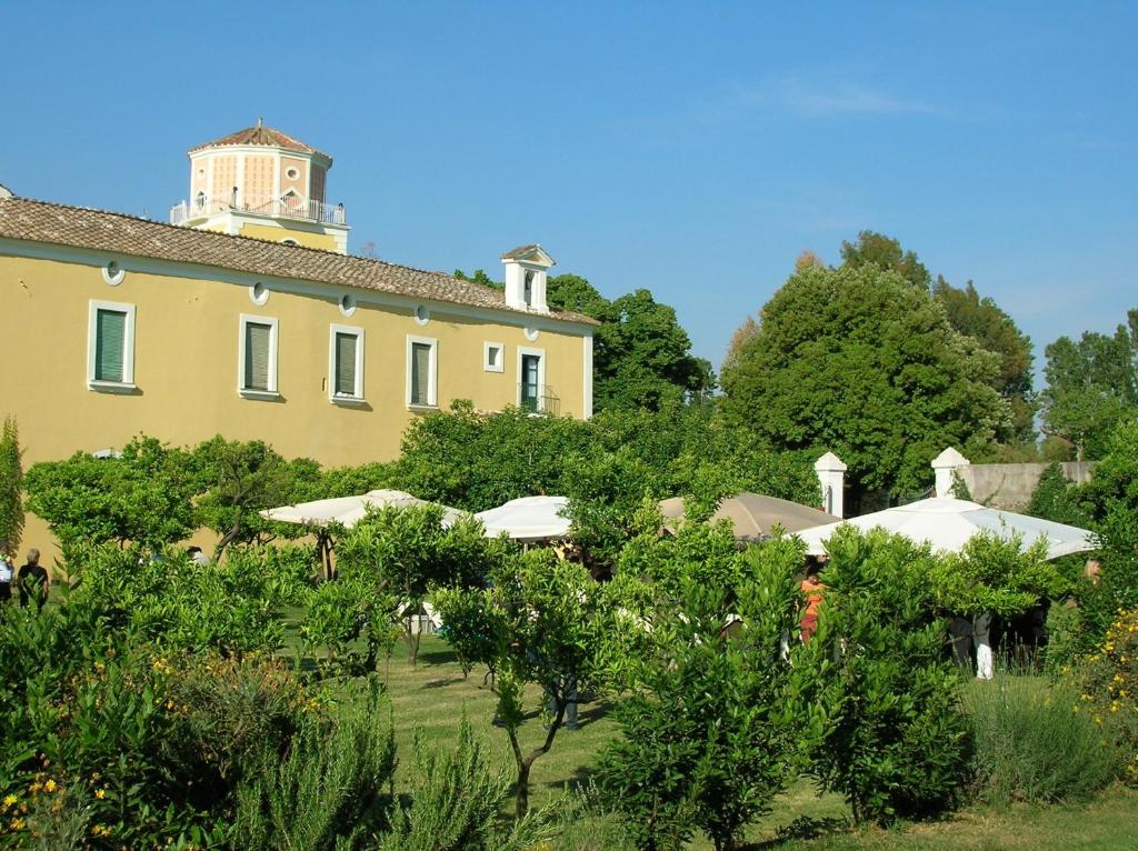 Una gran casa amarilla con una torre encima. en Farmstay La Morella, en Battipaglia