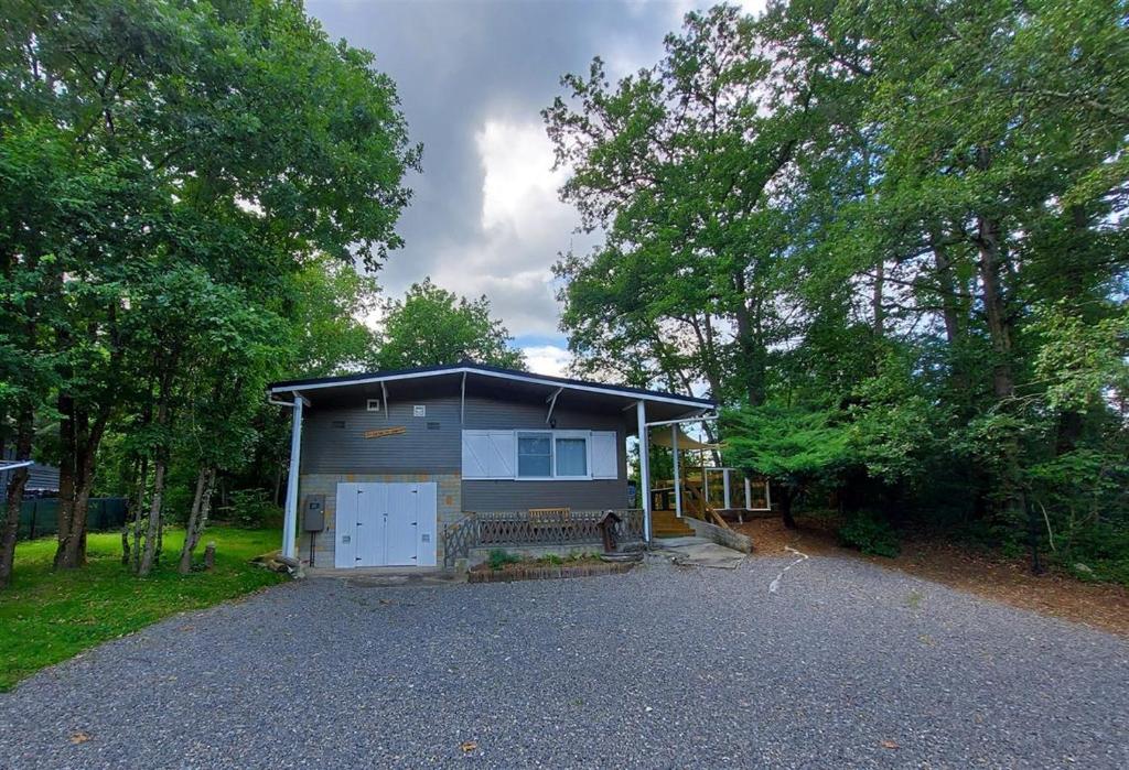 a small house with a garage on a driveway at Chalet Noisette in Durbuy