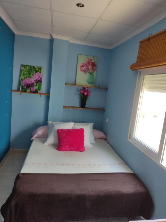 1 dormitorio con paredes azules y 1 cama con almohada roja en Playa Rihuete 2 en Puerto de Mazarrón