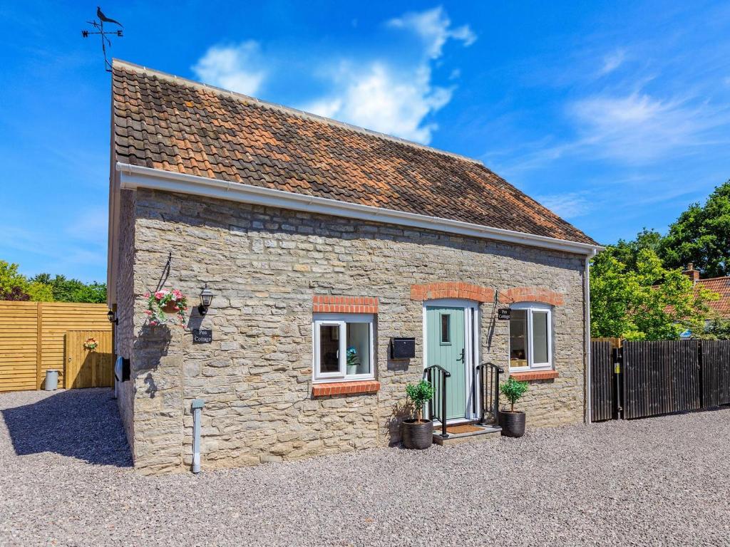 un cottage in pietra con porta blu di Pea Cottage a Ilchester