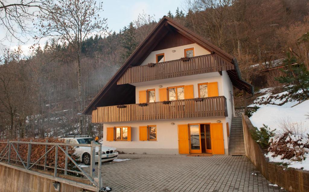 a house with orange doors in the snow at Holiday Home Zelenka in Cerklje na Gorenjskem