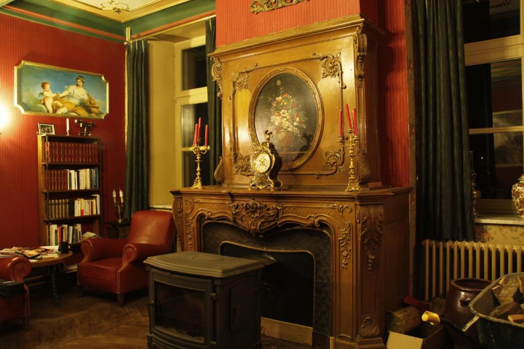 a living room with a fireplace with a clock on it at Tromcourt in Faubourg Saint-Germain