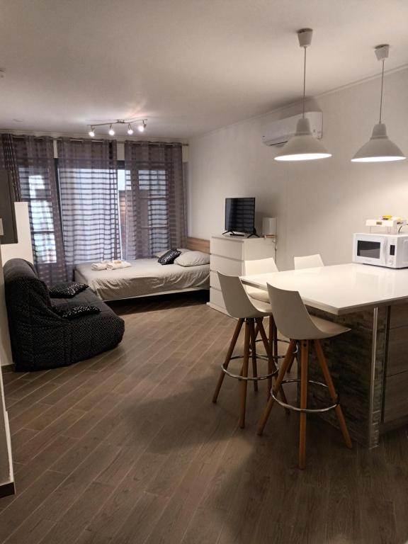 uma cozinha e sala de estar com uma mesa e um sofá em Studio Centre ville Castellane em Castellane