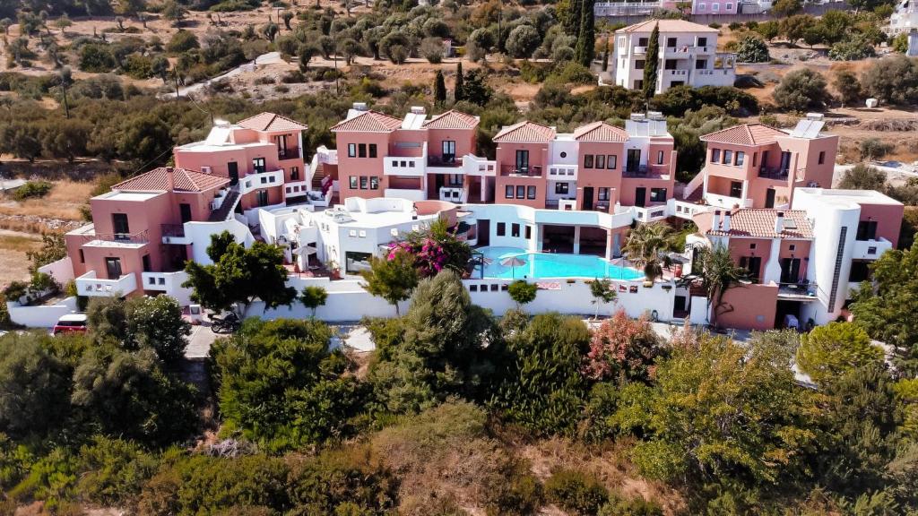 uma vista aérea de uma villa com casas cor-de-rosa e brancas em Nisea Hotel Samos em Pythagoreio