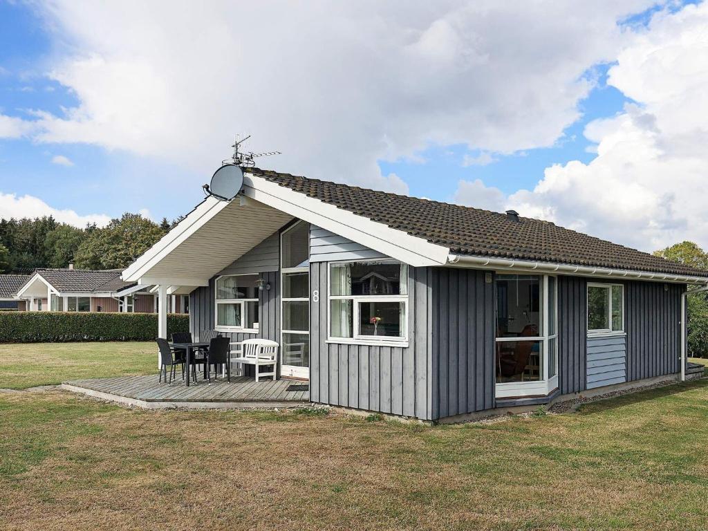 a small house with a porch and a deck at 6 person holiday home in Rudk bing in Spodsbjerg