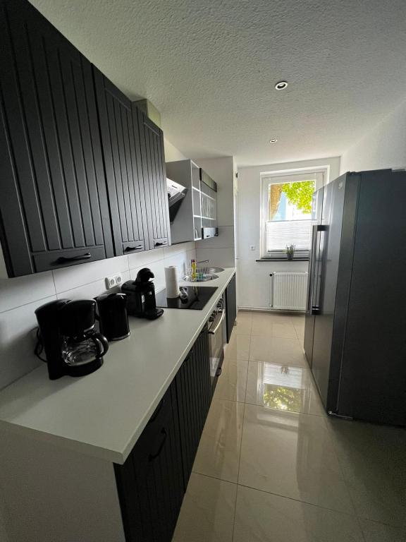 a kitchen with black cabinets and a white counter top at Ferienwohnung Carlos 1 und 2 in Bad Harzburg
