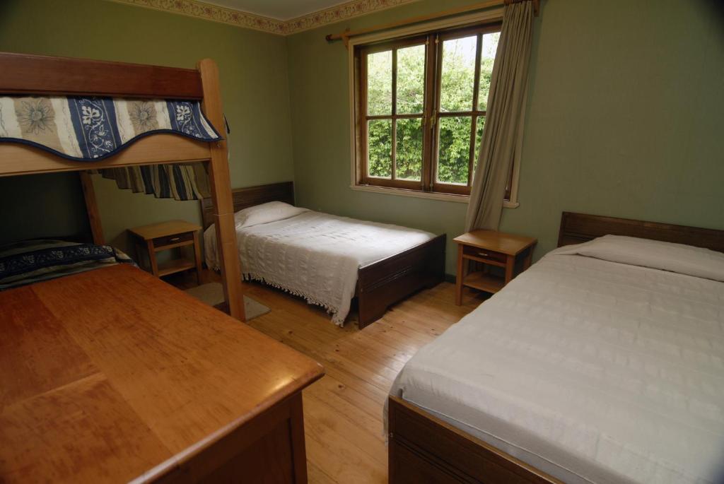 Un dormitorio con dos literas y una ventana. en Mavidahue, en llifen