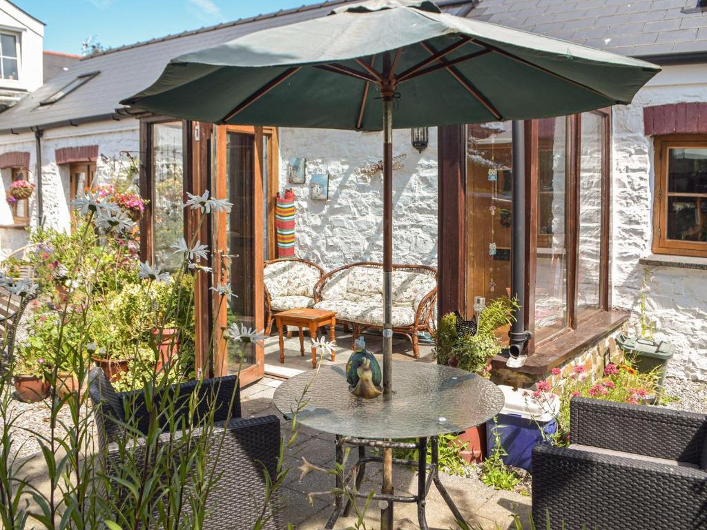 a patio with a table and an umbrella at Swallow Barn in Haverfordwest