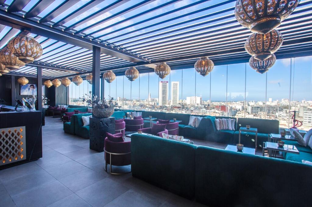 un restaurant avec des canapés et une vue sur la ville dans l'établissement W-Aldorf, à Casablanca