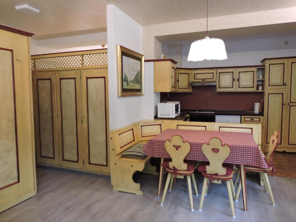 De Prealon Apartment في موينا: مطبخ مع طاولة و كرسيين بقلوب عليه