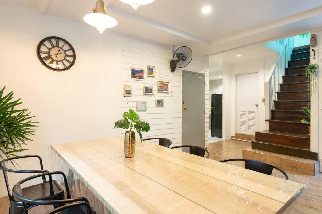 uma sala de jantar com mesa e cadeiras e um relógio em Thai private House in old town Bangkok 3 bedrooms* em Bangkok Noi