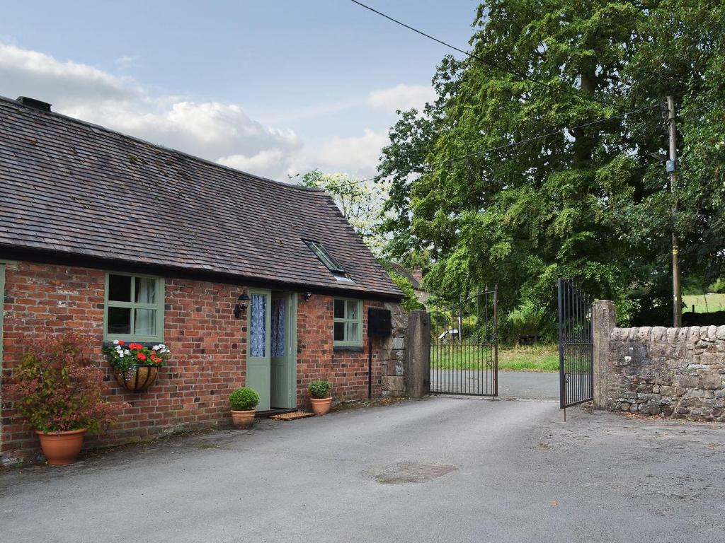 a brick house with a gate in front of it at Honeysuckle Cottage - Uk4177 in Mayfield