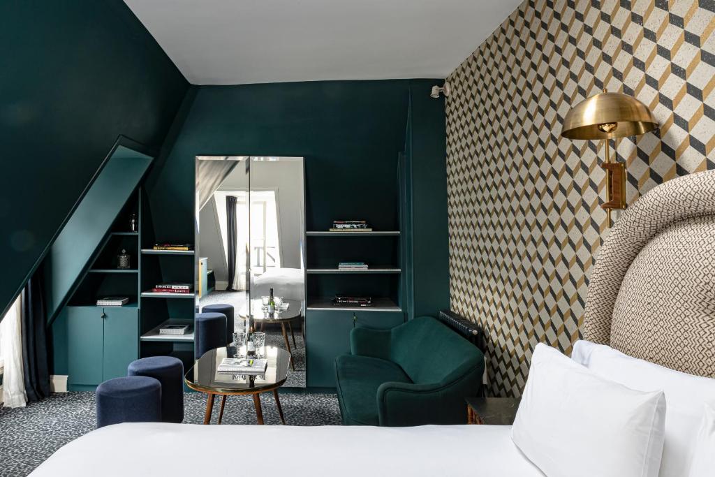 a bedroom with green walls and a bed and a mirror at Grand Pigalle Hotel in Paris