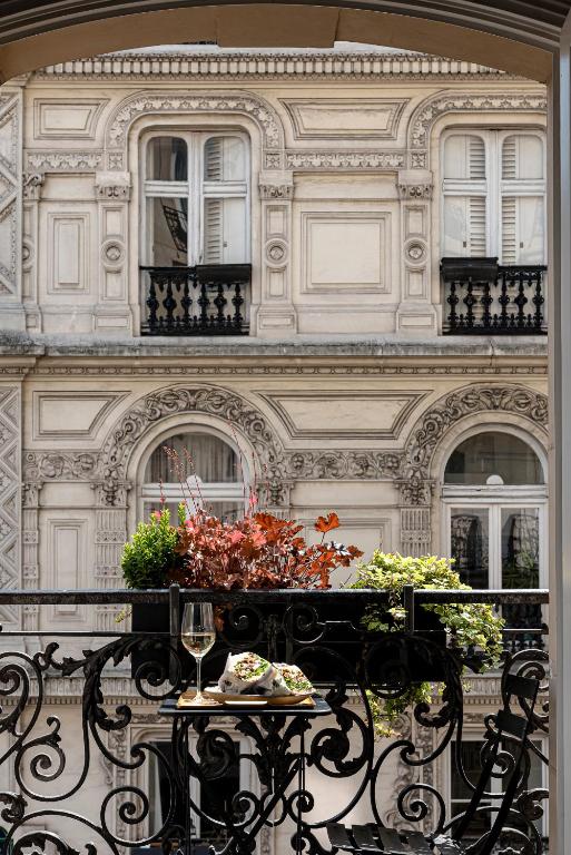 a table with flowers on a balcony with a building at Grand Pigalle Hotel in Paris