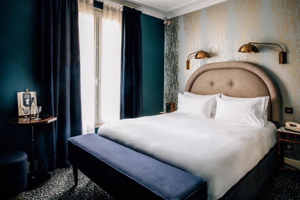 a bedroom with a large white bed and a window at Grand Pigalle Hotel in Paris