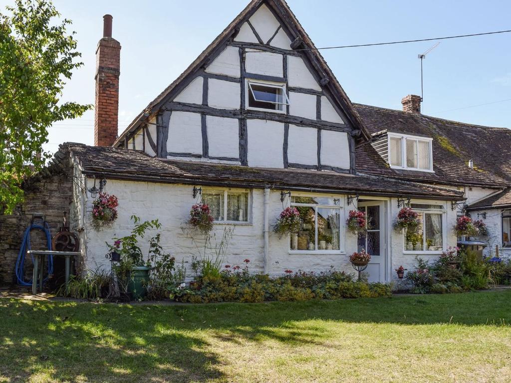 an old white house with flowers on the windows at Tudor Cottage in Bidford