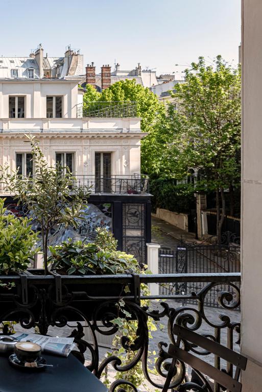 a balcony with a table and benches and a building at Grand Pigalle Hotel in Paris