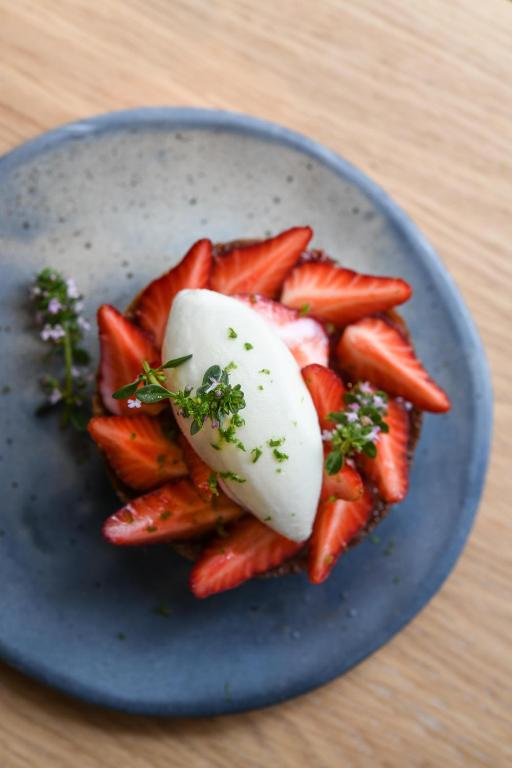 a blue plate with strawberries and cheese on a table at Grand Pigalle Hotel in Paris