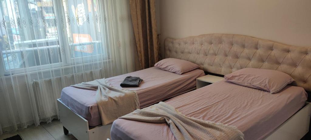 2 camas individuales en una habitación con ventana en Midtown Hotel Apartments 404 ( 2+1) en Estambul