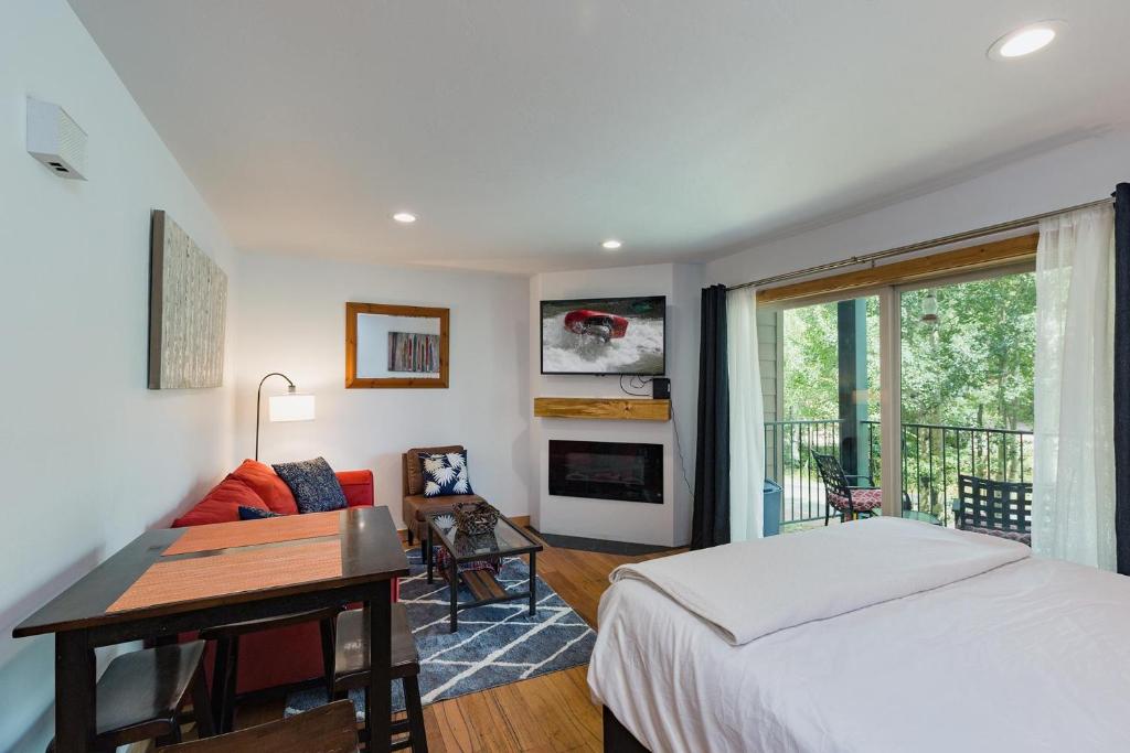 Schlafzimmer mit einem Bett, einem Schreibtisch und einem Kamin in der Unterkunft Studio Purgatory Townhome 104 in Durango Mountain Resort