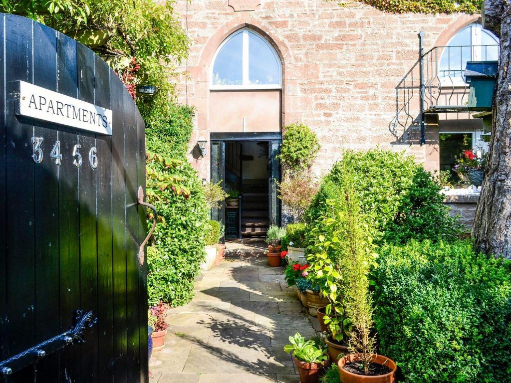 a garden entrance to a brick building with plants at Church Cottage in Rigg
