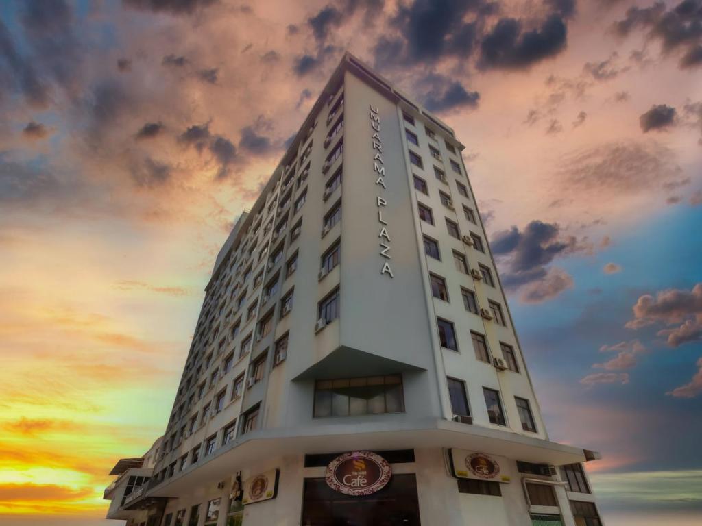 a tall white building with a sunset in the background at Umuarama Plaza Hotel by Castelo Itaipava in Goiânia