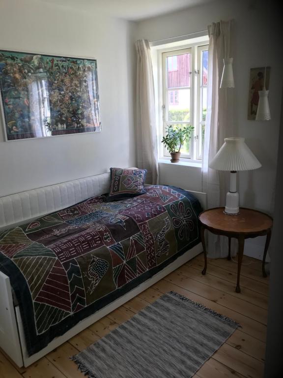 a bedroom with a bed and a table and a window at Vidunderligt hus på smukke Nyord in Stege