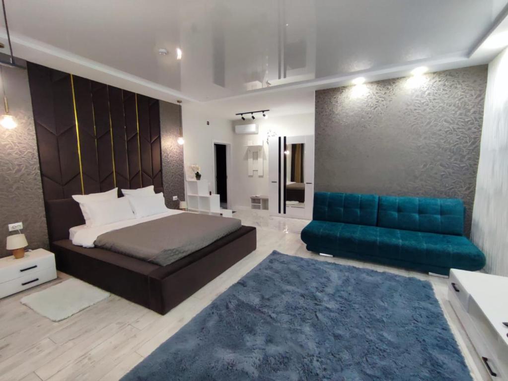 ウラリスクにあるZest hotel & spaのベッドルーム(ベッド1台、青いソファ付)