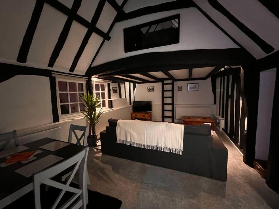 ein Wohnzimmer mit einem Sofa und einem Bett in der Unterkunft Historic Grade 2 listed, Town centre, St.Neots Cambridgeshire in Hail Weston