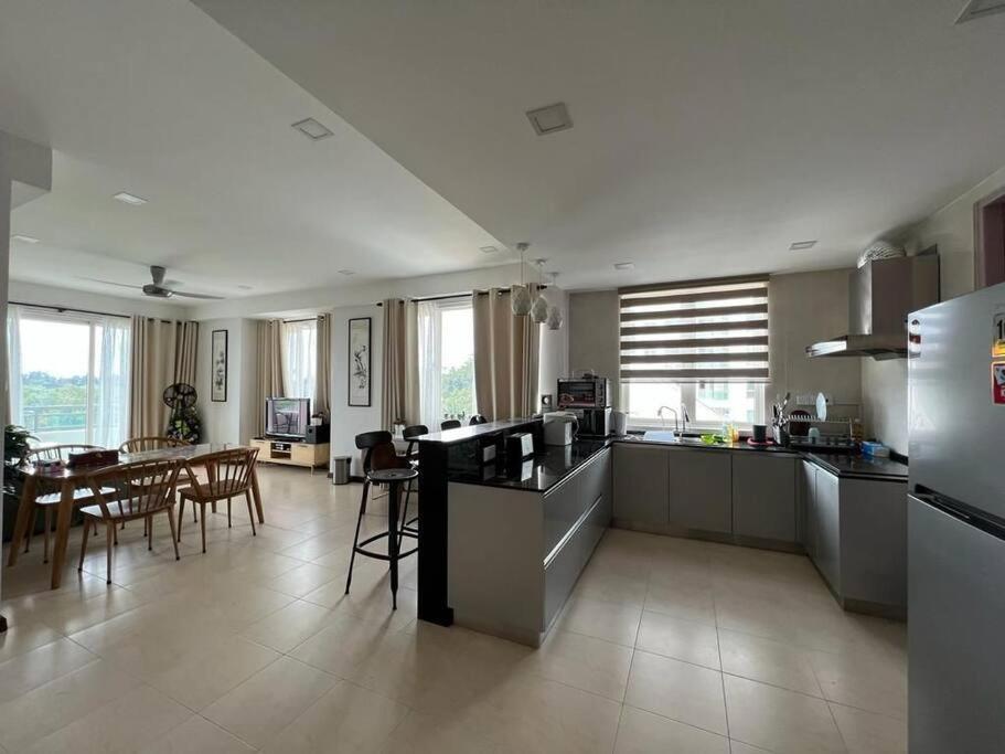 cocina y sala de estar con mesa y sillas en Santubong Suites Sejinjang en Kuching