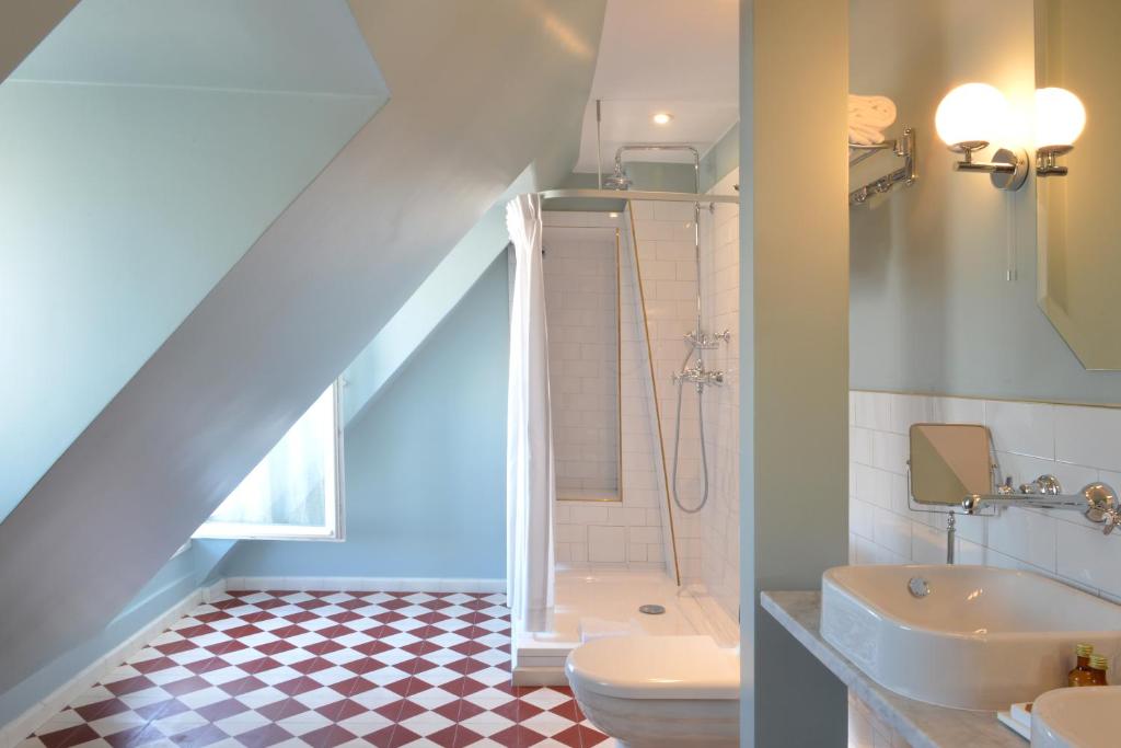 a bathroom with a toilet and a sink and a shower at Grand Pigalle Hotel in Paris