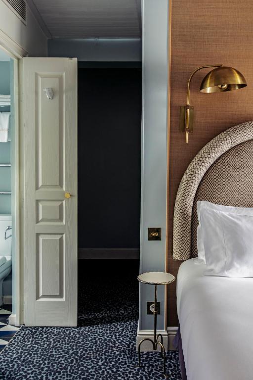 a bedroom with a bed and a door and a table at Grand Pigalle Hotel in Paris