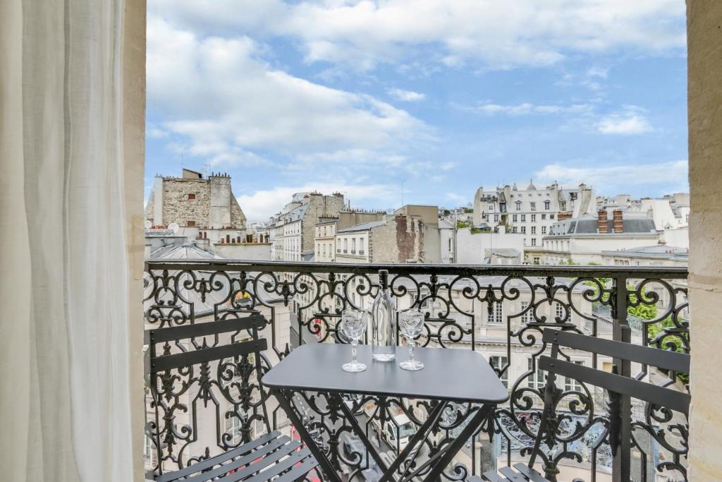 a table on a balcony with a view of the city at Grand Pigalle Hotel in Paris