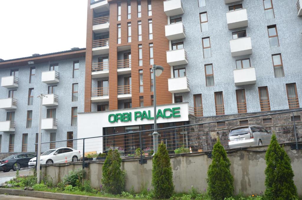an apartment building with a sign that reads open palage at Orbi Palace Deluxe Bakuriani Room 406 in Bakuriani