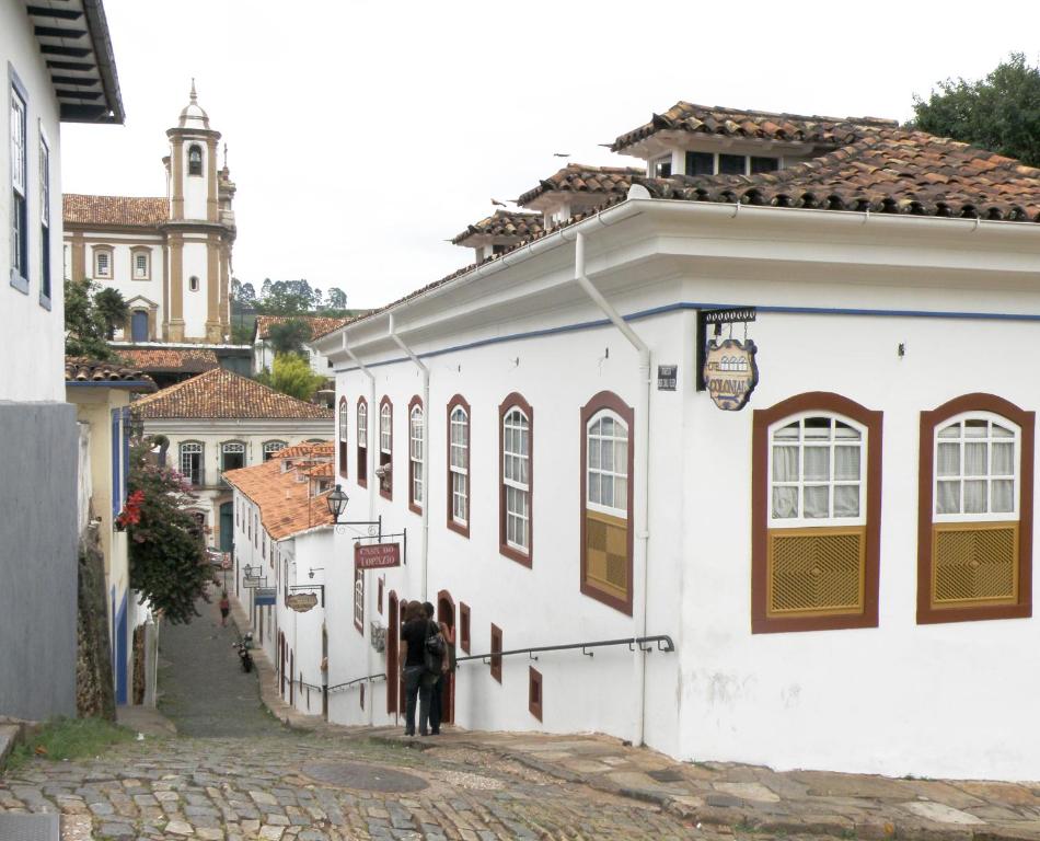 Eine Gruppe von Menschen, die eine Straße entlang gehen in der Unterkunft Hotel Colonial in Ouro Preto