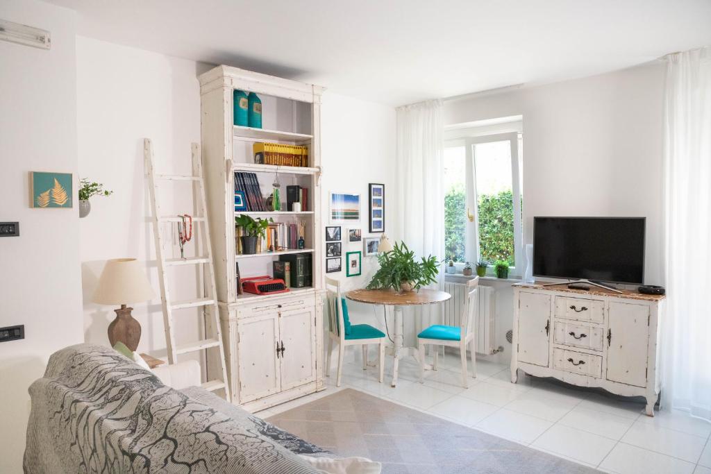 uma sala de estar com um sofá, uma mesa e uma televisão em La Casa di Mila em Fermo