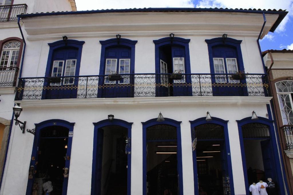 歐魯普雷圖的住宿－Hotel Barroco Mineiro，白色的建筑,设有蓝色的窗户和阳台